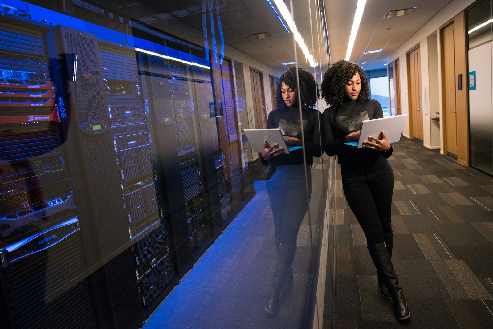 A RocKeen engineer reviewing work on a laptop in a data centre corridor
